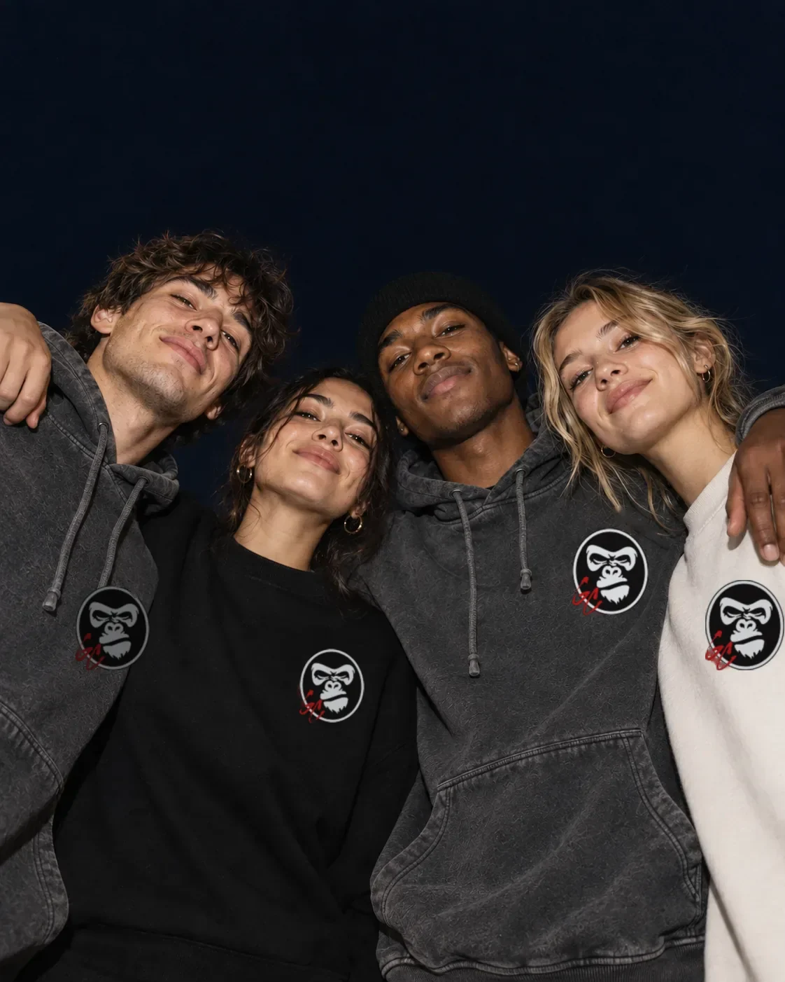 Illustrative campaign: four adult friends in GC clothing huddled together at night, looking down into the camera